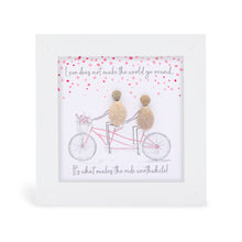  This white shadowbox framed pebble art print features a lovely couple on romantic tandom bike ride together with flowers in the basket on the front of the bike and read hearts floating above.&nbsp;It reads Love does not make the world go 'round, it makes the ride worthwhile.