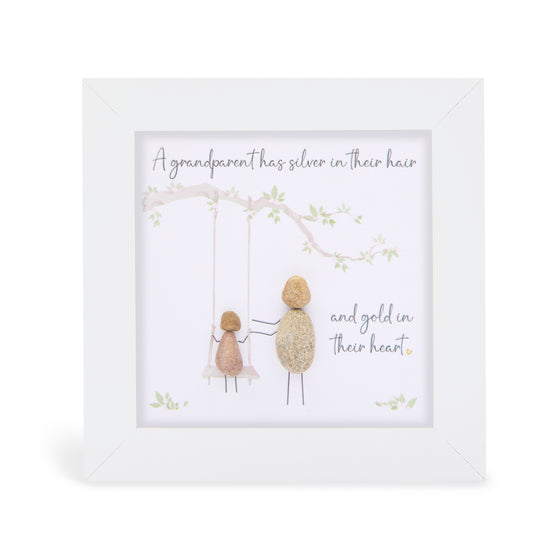 These small white shadow box frame gifts are made with a 4-inch white shadow box frame with a plexiglass insert, helping it be less fragile in the post and around the home. You can also easily take them apart to clean the inside of the glass or frame if you need to. They come individually boxed for added protection during shipping.

This white shadowbox framed pebble art features an adult pushing a child on a swing. It reads A grandparent has silver in their hair and gold in their heart