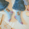 Head clover heels, high quality bamboo socks for women. On a baby blue butterfly backround features a beautiful illustration of a rabbit holding flowers by Hannah Dale. A perfect gift for animal lovers. Sock size 4 to 7. Wrendale Designs.