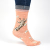 Flowers, a warm pair of high qulaity, coral coloured bamboo socks for women. Designed by Hannah Dale, these socks feature a beautiful illustration of a giraffe, holding flowers stitched into the soft, floral fabric. A perfect gift for animal lovers. Sock size 4 to 7. Wrendale Designs